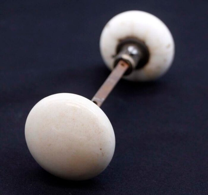 pair of mid 20th century white ceramic door knobs with black cast iron shanks 7101