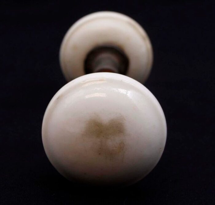 pair of mid 20th century white ceramic door knobs with cast iron shanks 7455