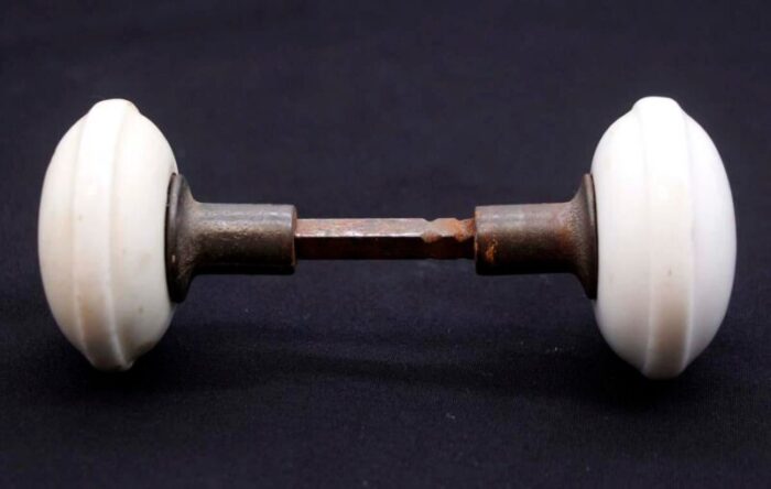 pair of mid 20th century white ceramic door knobs with cast iron shanks 9600